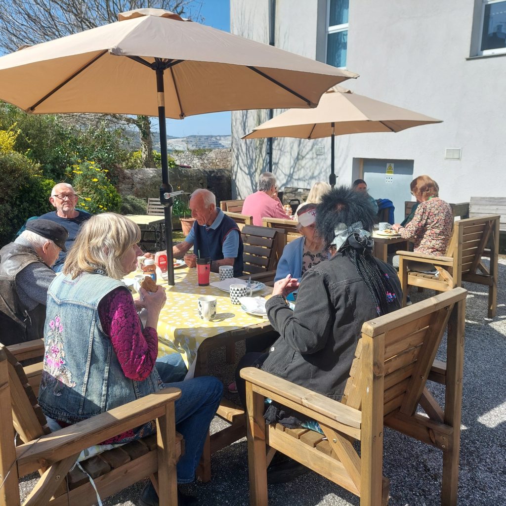 People enjoying lunch together in the ClayTAWC garden
